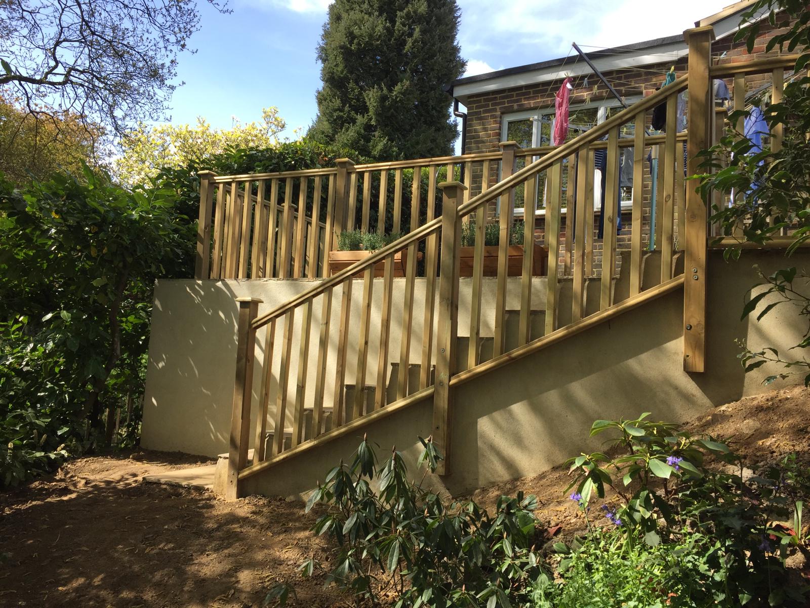 Timber balustrade and steps over a rendered retaining wall