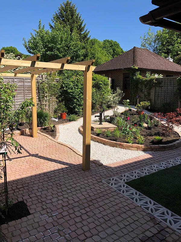 Courtyard rebuilt with clay pavers, an oak pergola and new planting