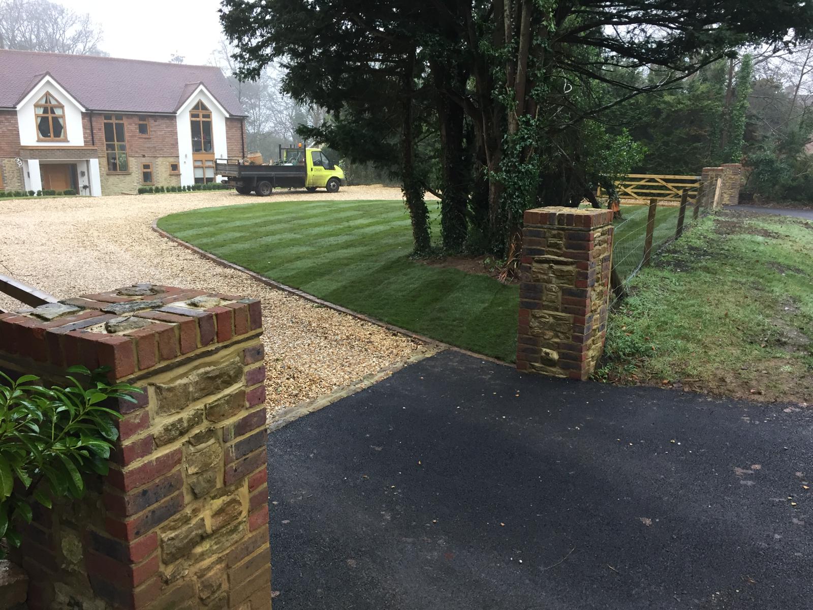 Gravel driveway with new turf lawn and brick and Bargate stone piers